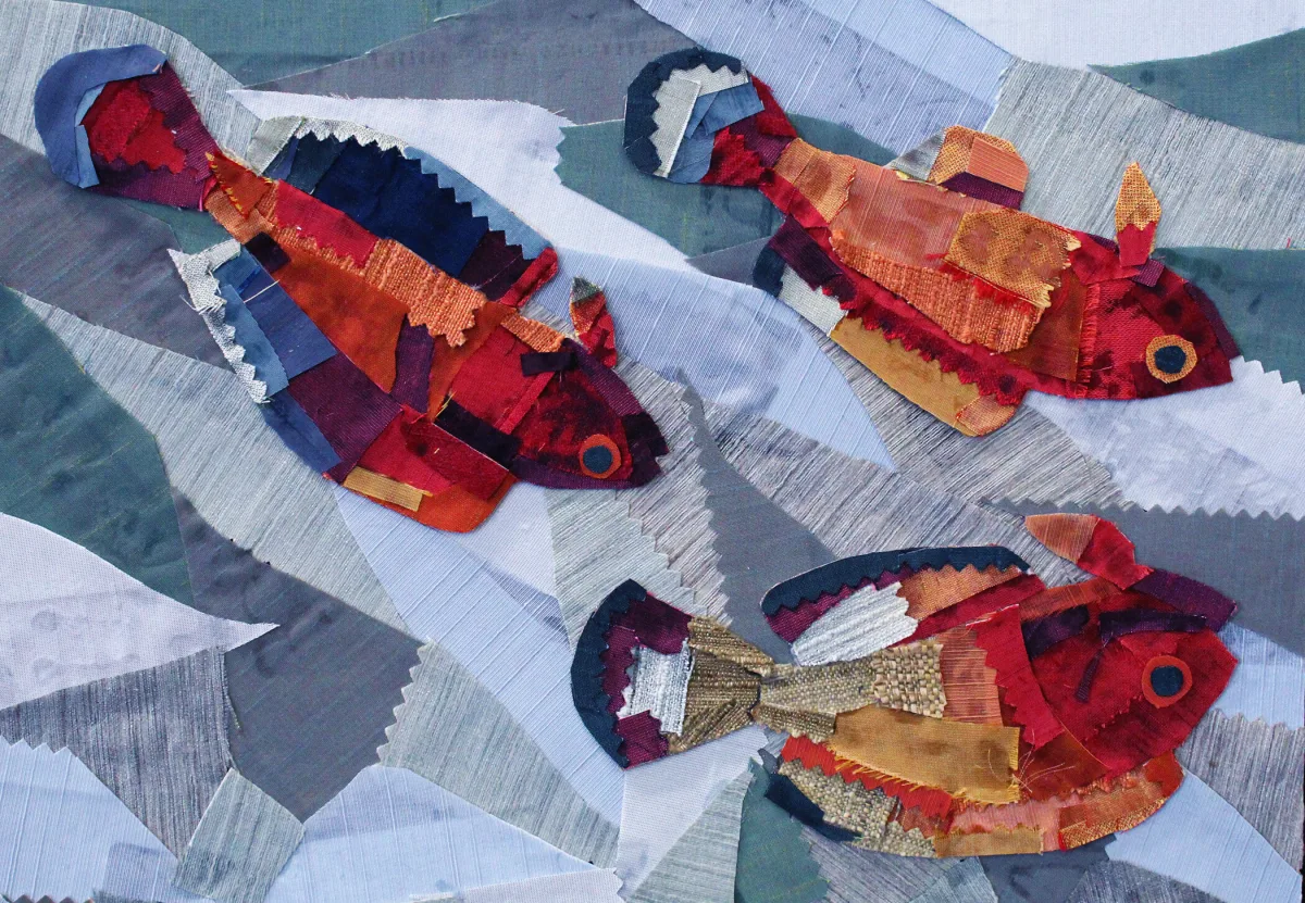 Fish sculpture assembled from overlapping scraps of colorful fabric