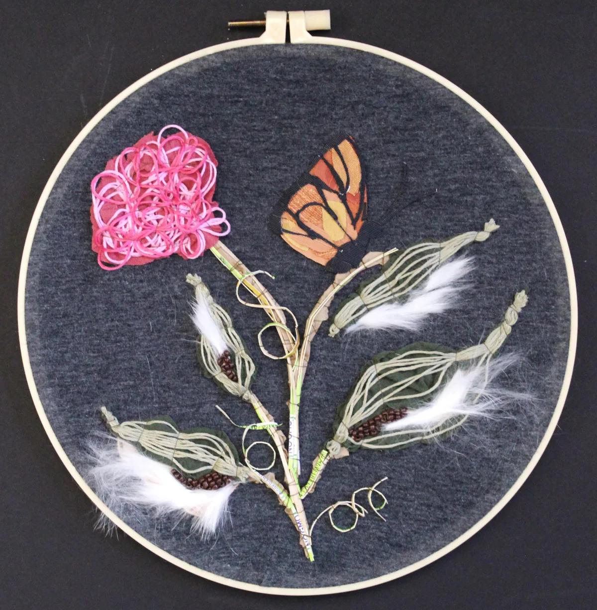 Textile monarch butterfly surrounded by fragmented habitat materials